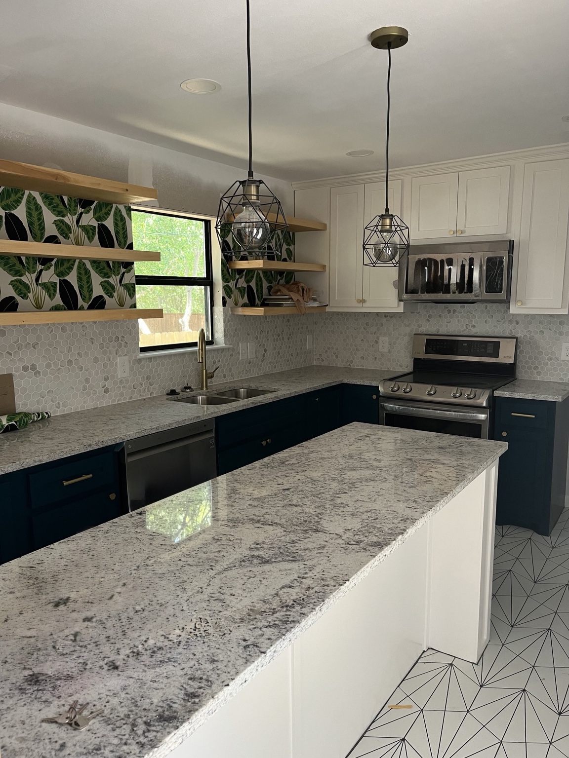 Blue and white kitchen with tropical accent wall